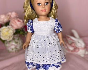 May include: A doll with blonde hair and blue eyes, wearing a blue headband and a white dress with blue floral accents. The dress has a white eyelet skirt and short sleeves. The doll is standing on a blue stand.