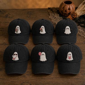 May include: Six black baseball caps arranged in two rows, each featuring a unique embroidered white ghost character. The ghosts are depicted holding flowers, wearing sunglasses with a bag, holding a pink balloon, or holding a red heart.