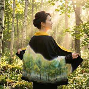 May include: A woman wearing a black kimono with a yellow collar and a forest scene design. The kimono features a gradient from black to a forest green and white design. The sleeves have black lace detailing.