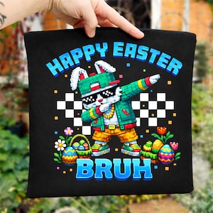 May include: Black tote bag with a pixelated Easter bunny wearing sunglasses, a green hat, and a gold chain. The words "HAPPY EASTER" and "BRUH" are in blue. Easter eggs and flowers are also featured.
