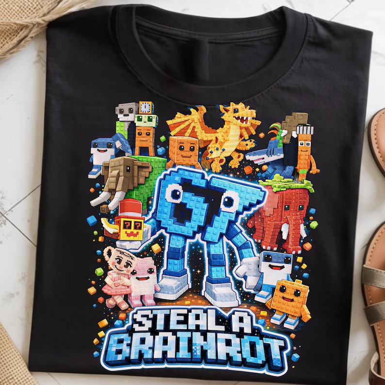 May include: Black t-shirt with a colorful graphic featuring pixelated creatures and the text "STEAL A BRAINROT" in a blue and white design. The design includes a large blue robot-like figure.