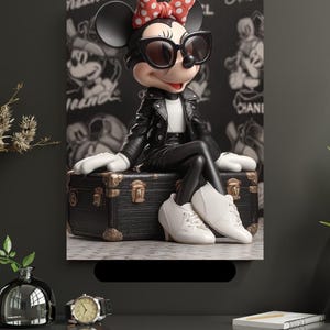 Peut inclure: Figurine de Minnie Mouse portant une veste en cuir noire, des lunettes de soleil et des chaussures blanches, assise sur une malle noire. Le fond présente un motif noir et blanc de Minnie Mouse. Un nœud rouge à pois orne sa tête.