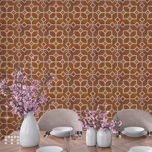 K&ouml;nnte beinhalten: Ein Esstisch mit wei&szlig;en Vasen mit rosa Blumen. Der Tisch ist mit wei&szlig;en Tellern, Besteck und Gl&auml;sern gedeckt. Der Hintergrund zeigt eine braun-wei&szlig; gemusterte Wand.