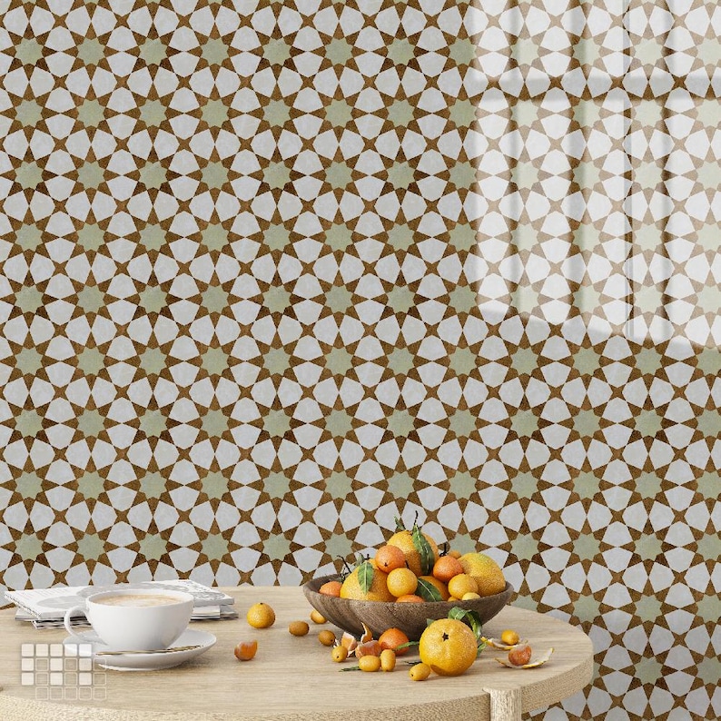 May include: A wooden table with a white teacup and saucer, a bowl of oranges, and a patterned wall in the background. The wall features a repeating star pattern in brown and green against a white background. The table is made of light-colored wood.