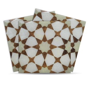 May include: Four square tiles with a repeating star pattern in white, brown, and light green. The tiles are arranged in a slightly overlapping manner, showcasing the intricate geometric design. The tiles have a glossy finish.