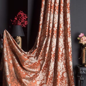Pu&ograve; includere: Tenda color ruggine con un motivo floreale bianco sporco. Il tessuto &egrave; drappeggiato, rivelando l'intricato design. La tenda &egrave; un elemento decorativo, che aggiunge un tocco di raffinatezza alla stanza.