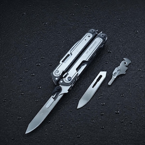May include: A silver Leatherman Arc multi-tool in a folded position with one blade extended. Beside the tool lies a separate, detached metal blade and a small metal component. The tool features visible screws and the text Leatherman Arc.