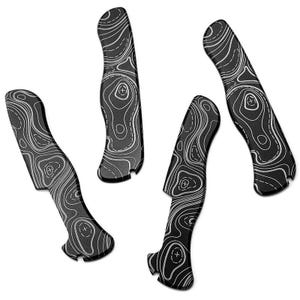 Puede incluir: Cuatro cachas de cuchillo con estampado en blanco y negro. Las cachas tienen un diseño de mapa topográfico con líneas blancas sobre un fondo negro. Las cachas son curvas y tienen una forma única.