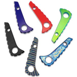 Può includere: Una collezione di sei utensili in metallo dal design unico. Ogni utensile presenta una forma curva con un foro circolare e un bordo seghettato. Gli utensili sono in vari colori, tra cui nero, blu, rosso, verde e una finitura a motivi.