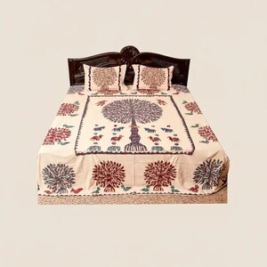 Pode incluir: Um edredom e duas fronhas creme com um desenho de árvore da vida. A árvore está no centro, com padrões florais vermelhos e azuis nas bordas. A estrutura da cama é marrom escuro.