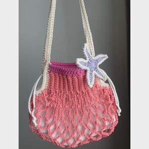 May include: A handmade crochet bag in shades of pink and white, featuring a net-like design. The bag has a drawstring closure and cream-colored straps. A lavender and white starfish embellishes the front, adding a nautical touch to this beach-themed accessory.