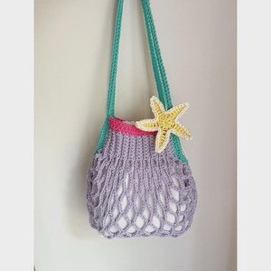 May include: A handmade crochet bag in shades of lavender, teal, and pink, adorned with a yellow starfish. The bag features a net-like design and long teal straps. A whimsical, beach-themed accessory.
