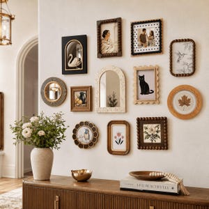 May include: A gallery wall arrangement featuring various picture frames in black, wood, and white finishes, including arched, circular, and rectangular shapes. The frames contain art prints of a swan, cat, bird, flowers, and a leaf, alongside a mirror.