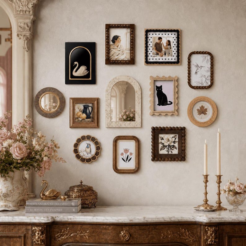May include: A gallery wall arrangement featuring various rectangular, circular, and arched frames containing illustrations of a swan, a cat, flowers, and a leaf. The collection includes ornate wooden, beaded, and scalloped frames on a wall.