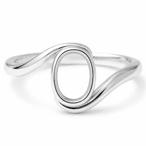 May include: A silver ring with a flowing, open design. The ring features a smooth, polished band that curves around an oval-shaped opening. The metal has a bright, reflective finish, creating a modern and elegant look. A minimalist piece of jewelry.