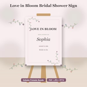 Può includere: Un cartello rosa chiaro su un cavalletto di legno con la scritta "Love in Bloom Bridal Shower Sign". Il cartello riporta la scritta "LOVE IN BLOOM", "BRIDAL SHOWER FOR Sophia", "AUGUST 9, 2026" e "Bride-to-be". Elementi floreali decorativi negli angoli.