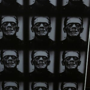 May include: A black and white grid of Frankenstein's monster portraits. The portraits are in a repeating pattern, each showing the monster's iconic features: flat head, bolts, and stitched neck. The image has a vintage, classic horror movie aesthetic.