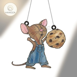 May include: A stained glass suncatcher featuring a cartoon mouse in blue overalls holding a large cookie. The mouse has brown fur, pink ears, and a smiling face. The suncatcher hangs from a chain and has the word "HANOZA" on it.