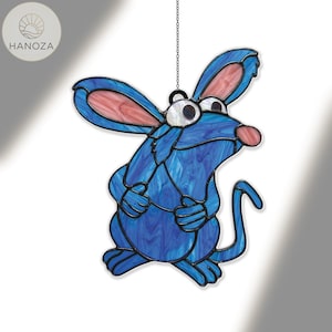 May include: A blue stained glass rat suncatcher with pink ears and nose, hanging from a chain. The rat has a cartoonish design. The glass has a marbled effect. The suncatcher is a decorative item.