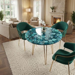 May include: A round dining table with a blue and green agate stone top, supported by gold-colored metal legs. Four green velvet chairs with gold legs surround the table, set on a cream-colored rug. The room has a fireplace and large windows.