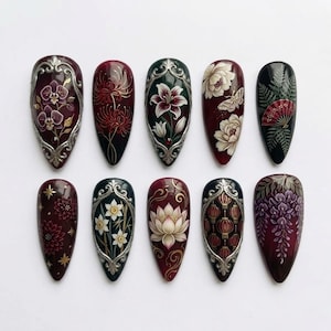 May include: A set of ten almond-shaped press-on nails featuring intricate hand-painted designs including orchids, lilies, lotus flowers, wisteria, and lanterns. The nails are decorated with metallic silver filigree accents and botanical motifs.