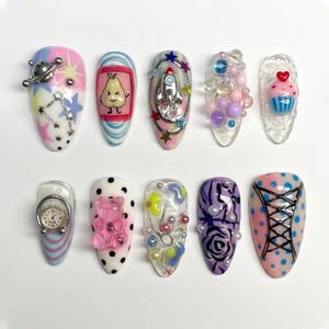 May include: A white ceramic mug with a black handle and the text "But First, Coffee" in a black, handwritten-style font. The mug is on a white surface.