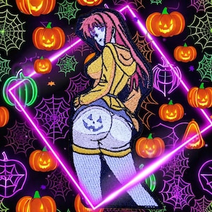May include: Embroidered Halloween patch featuring a cartoon figure with pink hair and a yellow hoodie, wearing shorts with a jack-o'-lantern design. The background is black with neon pumpkins, spiderwebs, and a pink geometric frame.