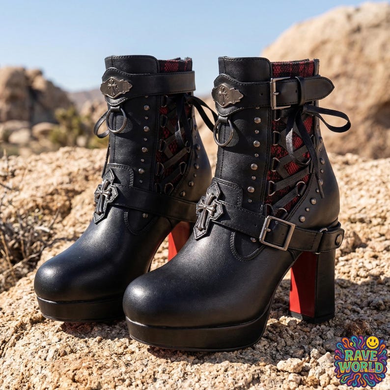 Gemini said
A close-up shot of a person sitting on sun-drenched desert rocks, showcasing edgy black platform ankle boots with chunky high block heels. These gothic-inspired boots feature multiple silver buckles, decorative straps, and eye-catching red mesh detailing along the sides. They boast a thick platform sole and a distinct red contrast on the rear of the heel. The person wears black distressed skinny jeans against a vast and rugged desert environment.