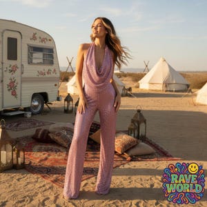 Op de afbeelding: Een glinsterende, roze pailletten jumpsuit met een halternek. De outfit wordt buiten gedragen met een vintage caravan en tenten op de achtergrond. De afbeelding bevat de tekst "RAVE WORLD" in een kleurrijk, psychedelisch lettertype.