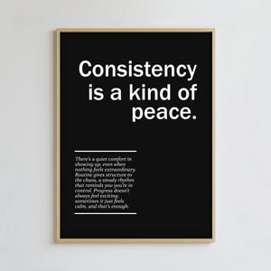 Puede incluir: Impresión en blanco y negro enmarcada con el texto "La consistencia es una especie de paz". La impresión incluye un párrafo de texto debajo de la cita principal. El marco es de color marrón claro.
