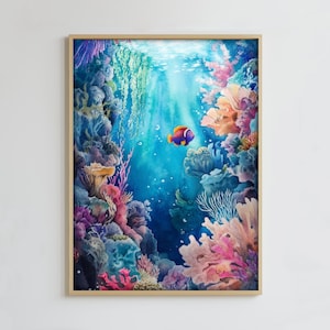 Op de afbeelding: Een ingelijste aquarelprint die een onderwaterlandschap weergeeft. Het kunstwerk toont een levendig koraalrif met verschillende kleuren, waaronder roze, oranje en blauw. Een kleurrijke vis zwemt in het heldere blauwe water, met lichtstralen van bovenaf.