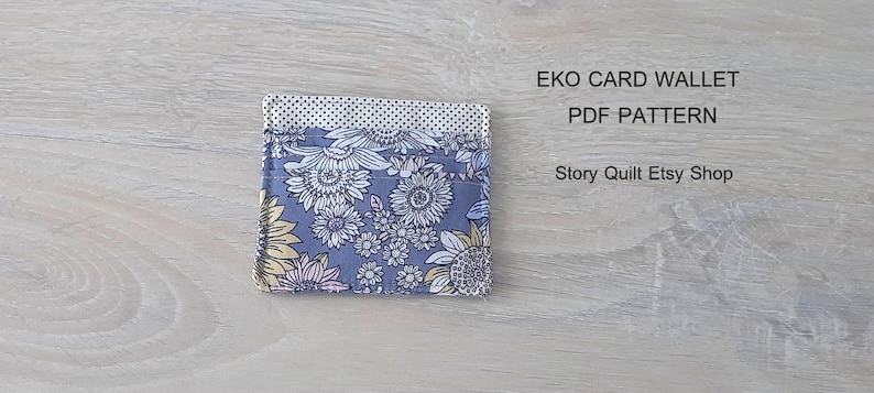 May include: A gray card wallet with a floral pattern in shades of yellow, pink, and white. The text "EKO CARD WALLET PDF PATTERN Story Quilt Etsy Shop" is printed above the wallet.
