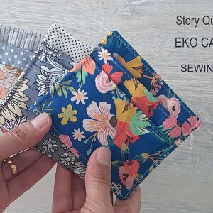 May include: Three colorful fabric card wallets with floral patterns. The wallets are folded and held in a hand. The text "Story Quilt Etsy Shop" and "EKO CARD WALLET SEWING PATTERN" is visible in the background.