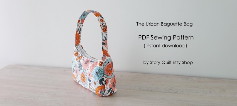 May include: A white fabric bag with a floral print in shades of orange, blue, and pink. The bag has a single strap and a zipper closure. The text "The Urban Baguette Bag" and "PDF Sewing Pattern (Instant download)" is visible on a white background. The text "by Story Quilt Etsy Shop" is also visible.