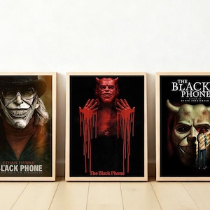 Puede incluir: Se muestran tres carteles enmarcados de la película "The Black Phone". Los carteles presentan imágenes de una figura enmascarada, un personaje demoníaco con sangre goteando y un primer plano de una máscara. Los carteles tienen un tema oscuro y ominoso.