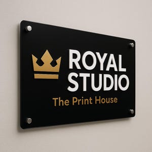 Puede incluir: Un letrero rectangular negro con las palabras "ROYAL STUDIO" en blanco y "The Print House" en dorado. Un logotipo de corona dorada est&aacute; a la izquierda. El letrero est&aacute; montado en una pared con separadores plateados.