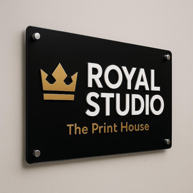 Puede incluir: Un letrero rectangular negro con las palabras "ROYAL STUDIO" en blanco y "The Print House" en dorado. Un logotipo de corona dorada est&aacute; a la izquierda. El letrero est&aacute; montado en una pared con separadores plateados.
