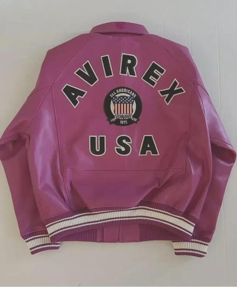 May include: A magenta leather jacket with the word "AVIREX" arched across the shoulders in black block letters. Below the word "AVIREX" is a circular patch with the words "ALL AMERICANS" and "ESTABLISHED 1975". The word "USA" is below the patch.