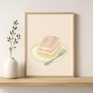 May include: Watercolor art print of a slice of tiramisu cake on a light green plate with a silver fork. The cake has layers of light brown and beige. The artwork is in a wooden frame.