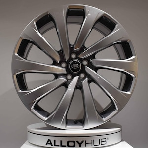 May include: A silver alloy wheel with a multi-spoke design. The wheel has a black centre cap with the Land Rover logo. The wheel is displayed on a white stand with the text "ALLOYHUB".