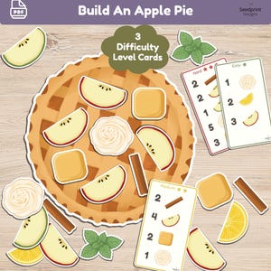 May include: A printable Build An Apple Pie activity set featuring a large illustrated pie crust, various apple slices, cinnamon sticks, lemon wedges, mint leaves, and whipped cream dollops, alongside three difficulty level cards labeled Easy, Medium, and Hard.