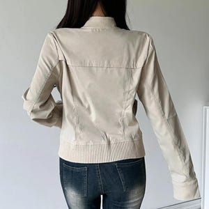 Women's Slim Fit Jacket | Casual Zipper Coats | Solid Streetwear Winter Fashion

Women wearing a slim-fit zippered jacket with long sleeves and a structured shape, styled with low-rise jeans for a modern streetwear look.