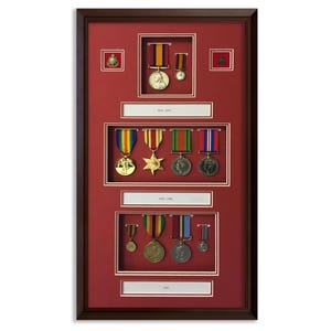 Könnte beinhalten: Gerahmte Präsentation von Militärmedaillen mit rotem Hintergrund. Die Medaillen, in verschiedenen Formen und Farben, sind in Reihen angeordnet und umfassen Bänder. Der Rahmen ist dunkelbraun.