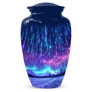 Pode incluir: Urna funerária azul marinho com um design celestial. A urna apresenta uma ilustração vibrante de um céu estrelado com estrelas cadentes, aurora boreal e uma paisagem nevada. A urna tem um acabamento brilhante.