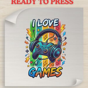 May include: A graphic design featuring a video game controller wearing headphones, surrounded by colorful vertical stripes, lightning bolts, stars, and hearts. The text reads I LOVE GAMES in bold, stylized lettering. The design is on a square sheet.