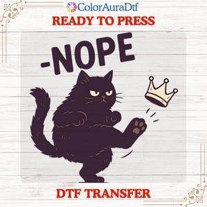 May include: A DTF transfer design featuring a grumpy black cat kicking away a crown. The word "-NOPE" is above the cat, and "READY TO PRESS" and "DTF TRANSFER" are printed at the top and bottom.