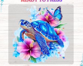 Op de afbeelding: Een DTF-transfer met een blauwe zeeschildpad met een patroon op zijn schild, omringd door roze en paarse hibiscusbloemen, blauwe vlinders en blauwe aquarelelementen. De teksten "READY TO PRESS" en "DTF TRANSFER" worden weergegeven.