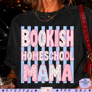 Könnte beinhalten: Ein schwarzes T-Shirt mit einem Grafikdesign aus hellblauen vertikalen Streifen. Der Text "BOOKISH HOMESCHOOL MAMA" ist in großen, blockartigen Buchstaben dargestellt, die mit verschiedenen rosa-weißen Mustern wie Blumen, Vichy-Karo und Punkten gefüllt sind.