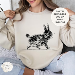 Könnte beinhalten: Beiges Sweatshirt mit einer schwarzen, gekritzelten Illustration eines Kaninchens. Das Design enthält den Text "DIGITAL DOWNLOAD 300 DPI QUALITY SVG-PNG". Das Sweatshirt ist Teil der Snappy67 Shop Kollektion.