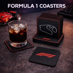 Könnte beinhalten: Schwarze Untersetzer mit rotem Rand, mit Formel-1-Logos und Streckenlayouts. Ein Glas Getränk mit Eis steht auf einem Untersetzer. Der Text "FORMULA 1 COASTERS" ist oben im Bild zu sehen.